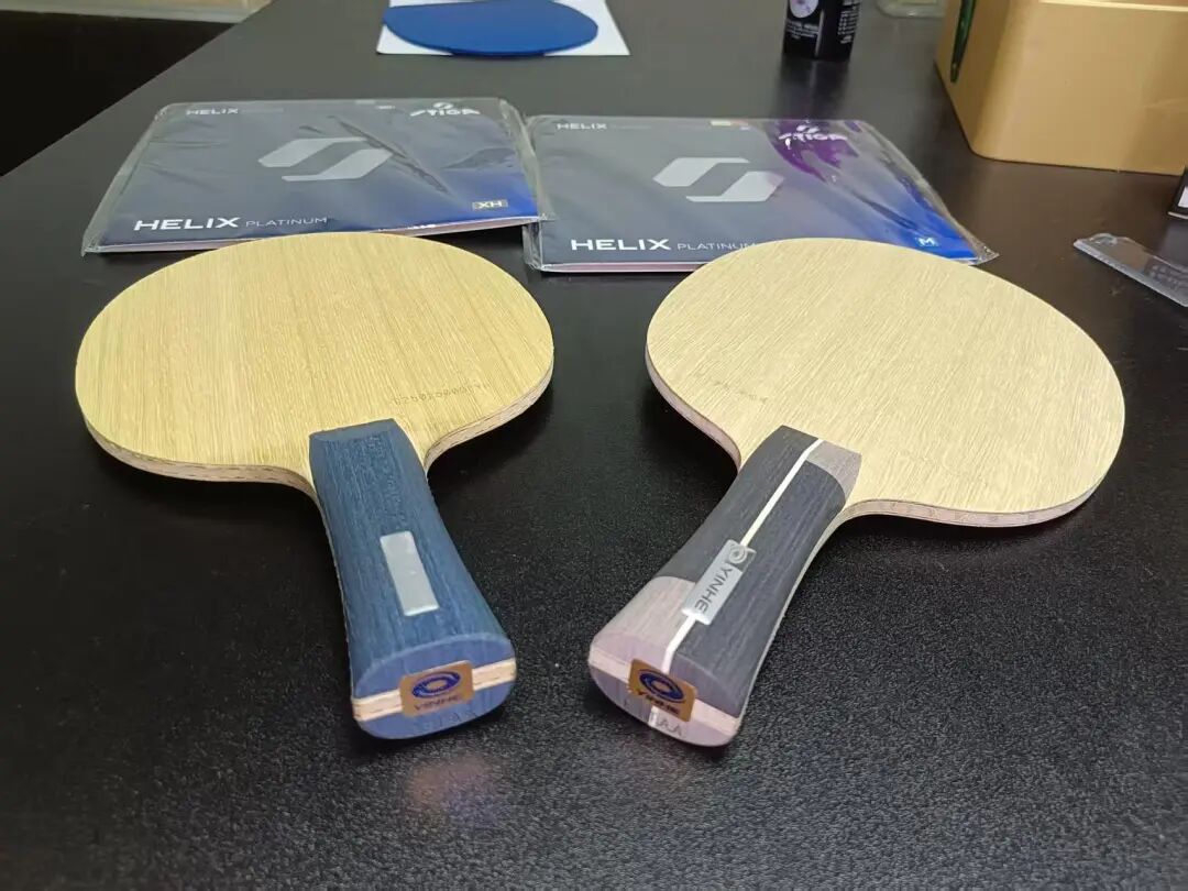 Koki Niwa holding two different blades — Koki Niwa ZC and all-wood version — before a match