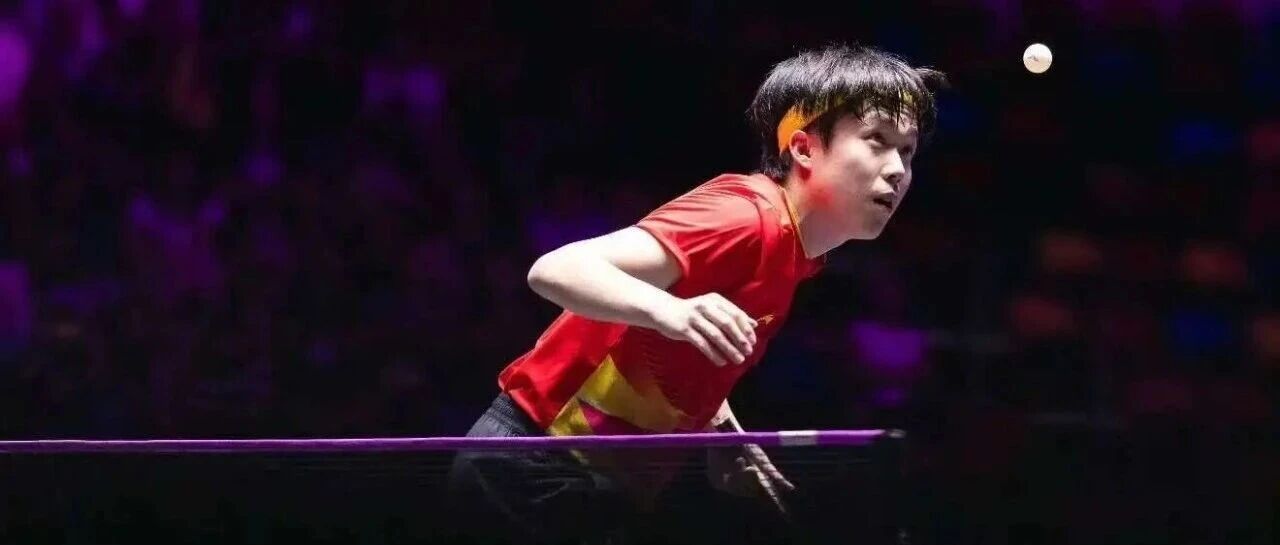 Sun Yingsha in action during a match, leaning forward over the table in red Chinese national team jersey