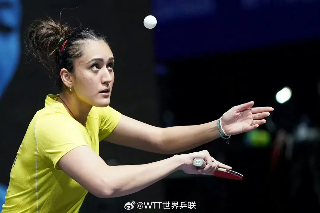 Table tennis player demonstrating backhand serve motion at the table